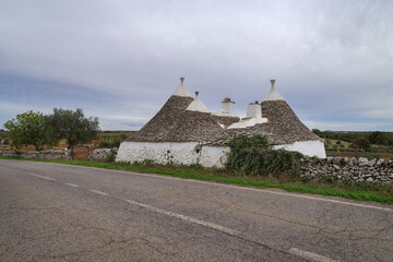 Typical trulli houses along country road in Puglia, Italy