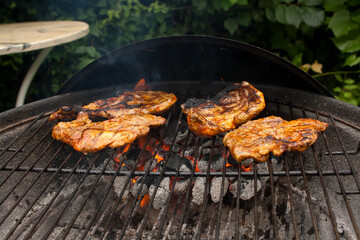 Grilling a juicy steak in the flames of a coal barbecue