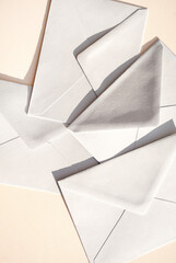 Gray paper envelopes on a beige background. Business or office concept. Flat lay. Top view