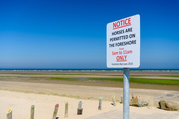 Sign at a beach, advising the public that horses are only permitted on the foreshore between 5am...