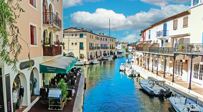 Port Grimaud, France - June 9. 2016: Mediterranean town, beautiful water canal with boats, vacation apartments and restaurant in summer