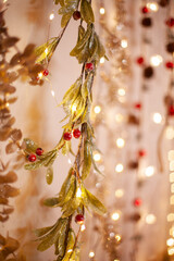 Christmas botanical garlands with red berries at market. Holiday season decoration lights bokeh vertical background.