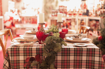 christmas table setting in red color palette with checkered classic tablecloth