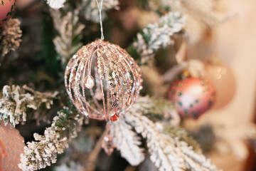 snow covered christmas tree pink bauble ball glitter shiny ornaments decoration. Xmas tree closeup home decor.