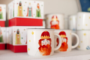 mugs with Three Kings holiday print design at shelf at christmas market