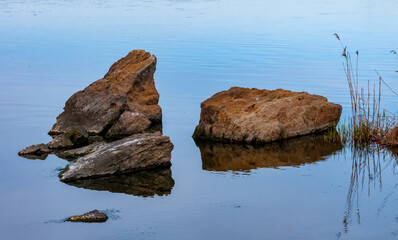 Coast with rocks in the water, Hadzhibey estuary. Reflection in water