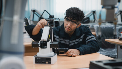 Student engineer Assembling Robotic Arm with computer in Technology Workshop. Service Engineer...