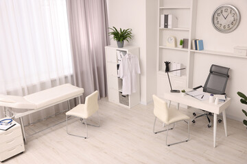 Modern medical office interior with doctor's workplace and examination table