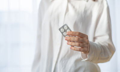 woman holding several vitamin pills and supplements in her hands