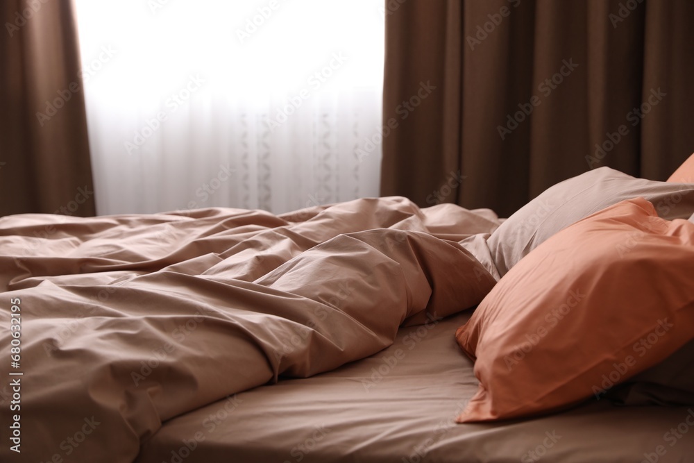 Poster Bed with orange and brown linens in stylish room