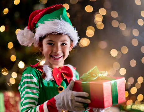 Christmas elf holding a gift box. Christmas background with copy space.