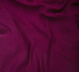 Crumpled dark red fabric used for sewing clothes for store. Textile material polyester,knitted or...