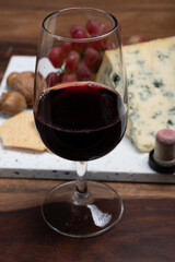 Red porto and cheese pairing, blue matured stilton English cheese served as dessert with walnuts and glass ruby porto wine