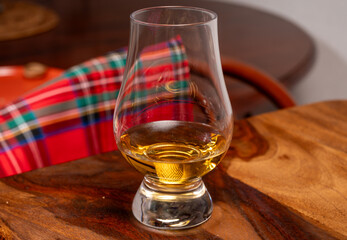Tasting of different Scotch whiskies strong alcoholic drinks, drum of whiskey and colorful Scotch tartan on background close up - obrazy, fototapety, plakaty