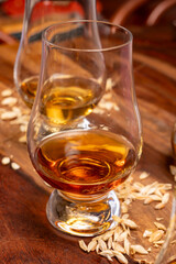 Tasting of different Scotch whiskies strong alcoholic drinks, drum of whiskey and colorful Scotch tartan on background close up