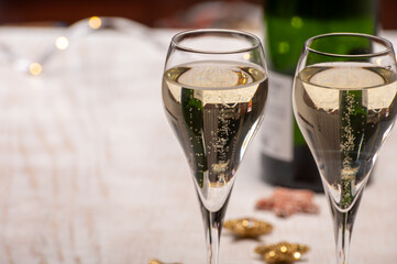 Glasses of bubble wine champagne, cremant, cava or prosecco and christmas stars for decoration
