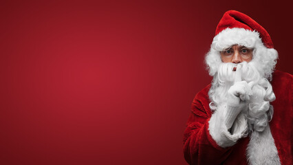 Santa Claus gesturing silence with finger on lips, mysterious holiday secret concept