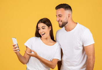 Happy shocked young european woman in casual show phone to man