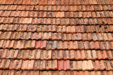 Roof top view. Red old tiles. The pattern of old roof tile. Orange old tile roof, abstract background. Roofing texture. Red corrugated tile element of roof. Seamless pattern.