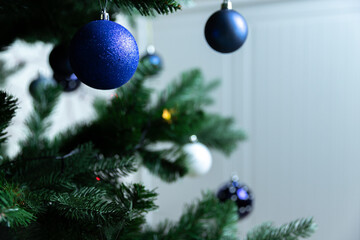 Christmas tree with blue, white balls and garland on a white background. Festive New Year's atmosphere