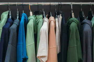 colorful jackets suits hoodies in the market . Multicolor family clothes on hangers in store