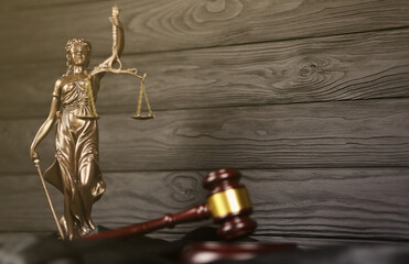 The Statue of Justice - lady justice or justitia the Roman goddess of Justice. Statue on brown book...