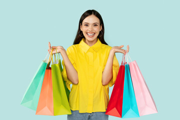 Fototapeta na wymiar Happy woman showing bunch of colorful shopping bags