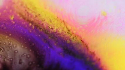 Paint splash. Glitter mist texture. Defocused neon purple yellow pink color gradient sparkling ink water wave motion art abstract background.
