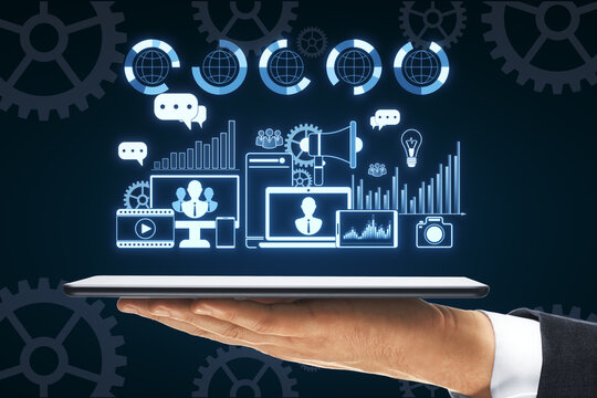 Close up male hand holding cellphone with creative digital marketing hologram on blue background. Promotion and analysis concept.