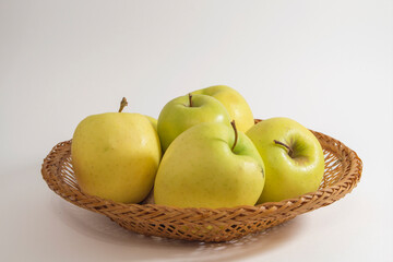 Basket with yellow apples golden variety, isolated on white background