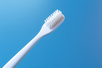 White toothbrush on a blue background. Dentistry, hygiene. AI generative.