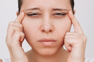 Young caucasian woman with poor eyesight squints pulling eyelids to the sides with hands isolated on white background. Vision focus