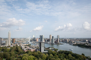 Obraz premium Cosmopolitan famous Dutch city Rotterdam with skyscraper buildings and river Nieuwe Maas. Aerial daytime view of skyline in Holland