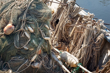 Wooden boats stern, ropes and fishing nets, and floats affected by weathered.