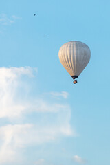 Nicely white hot-air balloon in the distance. Vertical photo.
