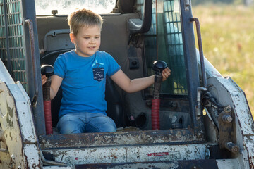 Fototapeta na wymiar A child's dream of driving a real tractor comes true