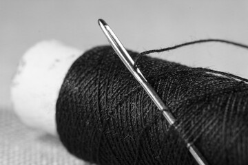 Sewing needle and spool of black thread