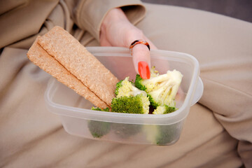 healthy snack with broccoli in lunch box. woman hands holding Lunch container