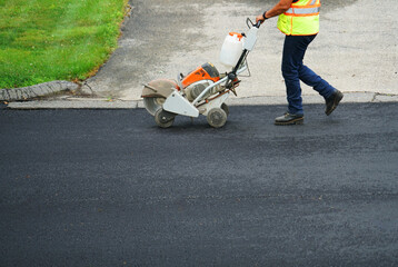 close up on worker on new paved asphalt road