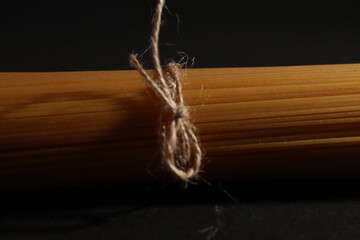 Espaguetis crudos atados con una cuerda en un fondo negro