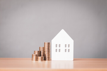 Home model and the stack gold coin with growing interest put on the desk in the office, Savings...
