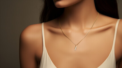 woman wearing  a strappy low neckline dress and a delicate minimalistic necklace with a golden pendant, closeup