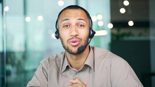 Webcam view. Customer service telemarketing male agent in office doing computer consultation with headset. Man call center consultant operator working on crm online in workplace Look at camera screen