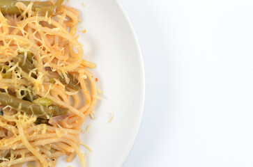 spaghetti with asparagus and meat stewed on a white plate