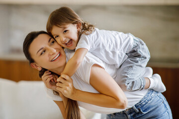 Fun With Baby. Happy Mom Playing With Adorable Toddler Daughter At Home