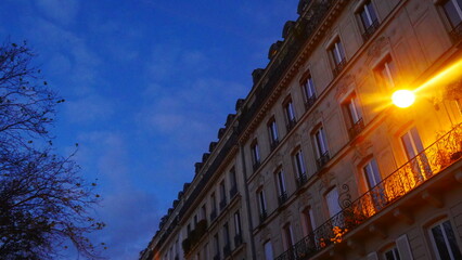 Façade de batiment urbaine et parisien, de quartier chic et ancien, en plein nuit, avec éclairage...