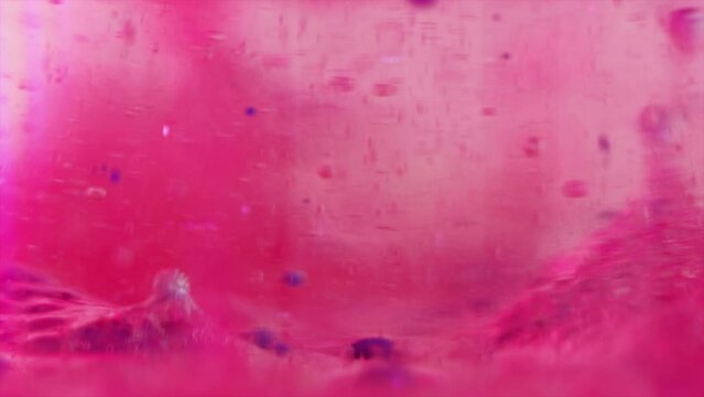 Gel bubbles texture. Paint drop. Jelly moisture. Defocused bright pink blue color translucent liquid ink oxygen floating motion art abstract background.