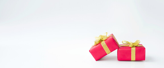 Banner, on a white background, beautiful red holiday boxes with a gold bow.  Space for copying text.  Holiday concept New Year and Christmas, Valentine's Day.  Seasonal promotions and sales.