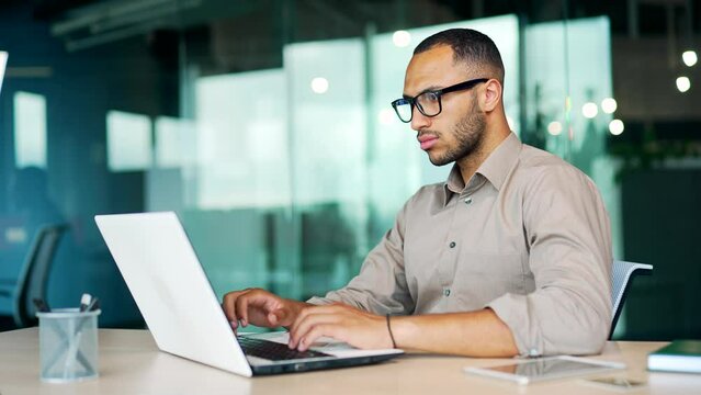 Pondering business guy thoughtful looking away thinking about information database on laptop computer during distance job in coworking space, freelancer copywriter Workflow use modern tech internet AI