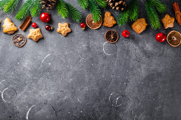 Christmas background cookies and fir branches on grey background top view free space for text....